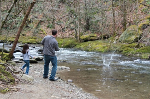 Mia and her daddy having fun skipping rocks on the river. 