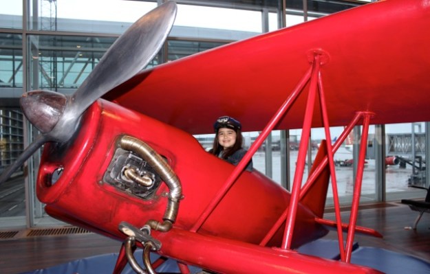 Maybe a future pilot... Mia having fun on a cool red plane at the Stockholm Airport.